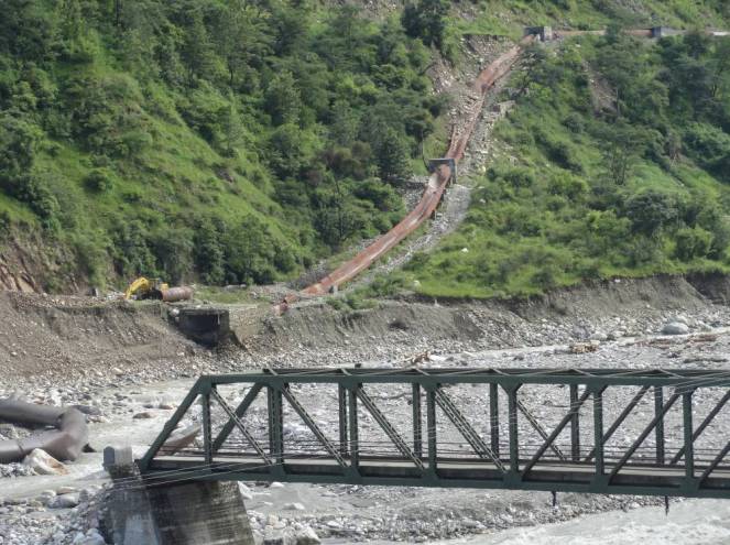 Damaged pipes (meant to carry the river water to the Gangani HEP power plant some 3 km d/s from the diversion head) and the damaged approach bridge on the river