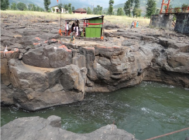 Devotees offering puffed rice to Mahseer below. Photo : Author