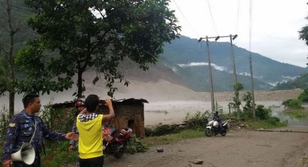 A man taking a photo of the artificial lake formed due to Sunkoshi River Blockade in Sindhupalchok
