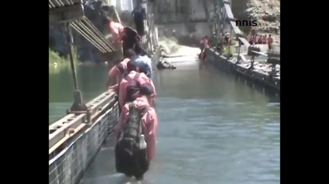 Kids crossing flooded bridge in flood hit J&K Photo Sources - NNIS