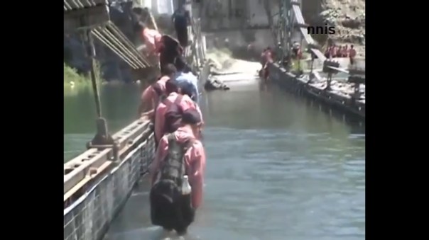 Kids crossing flooded bridge in flood hit J&K Photo Sources - NNIS