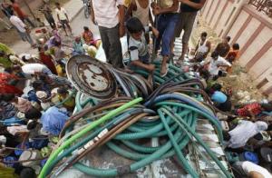 Slum dwellers collecting water from a water tanker (Source: India Water Portal)