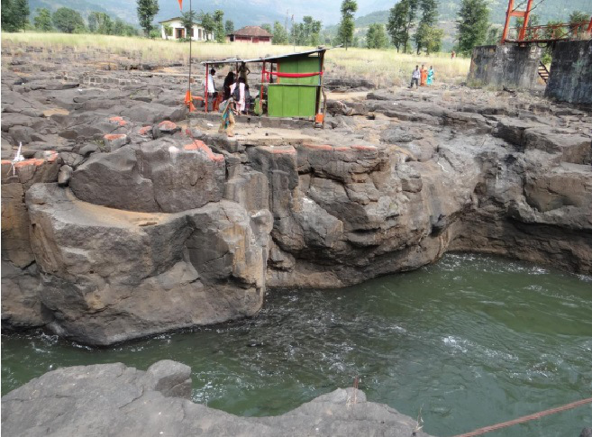 Throwing rice to the Mahseer congregating below Photo: Author