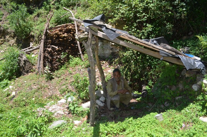 Lungtaya sitting at his now defunct Kharad unit, a wood working machine that uses the power of flowing water